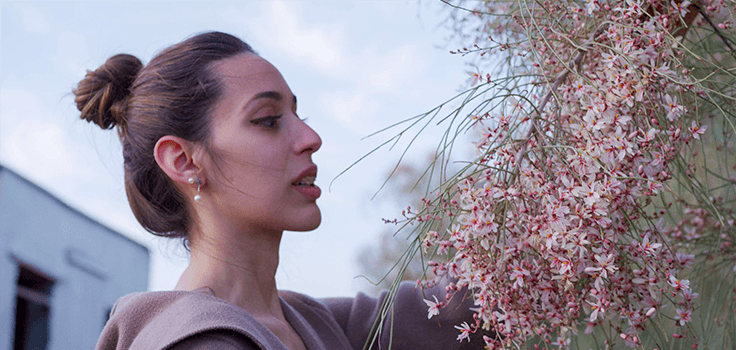 A woman looking at Moringa Peregrina flowers